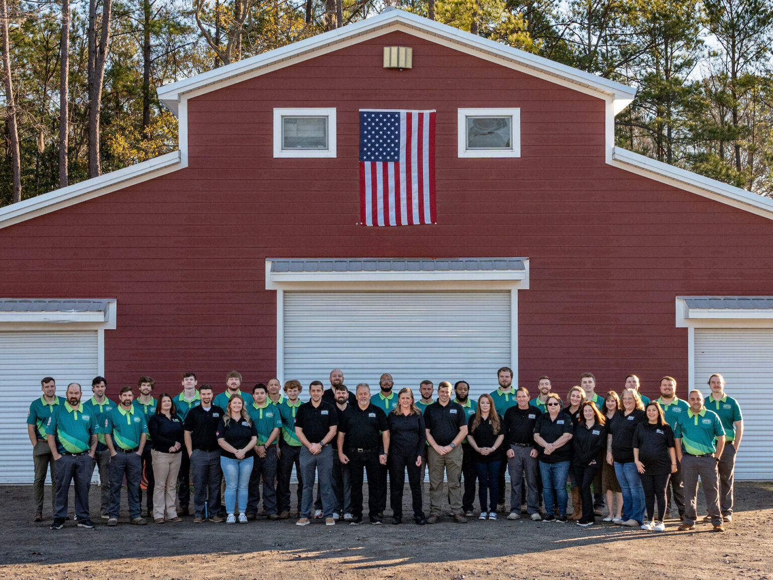 The full Blanton & Sons team gathered in front of the company's red barn shop in South Carolina