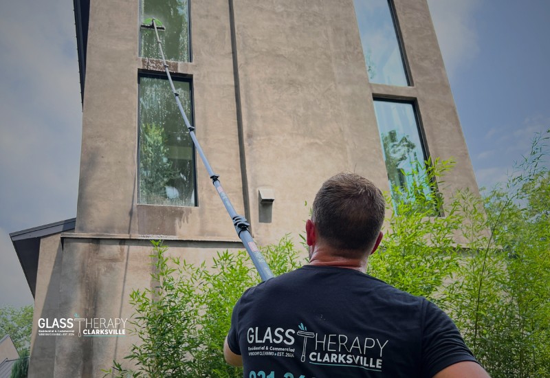 Glass Therapy Clarksville technician using a water-fed pole to clean upper-story windows on a residential property near Nashville, Tennessee