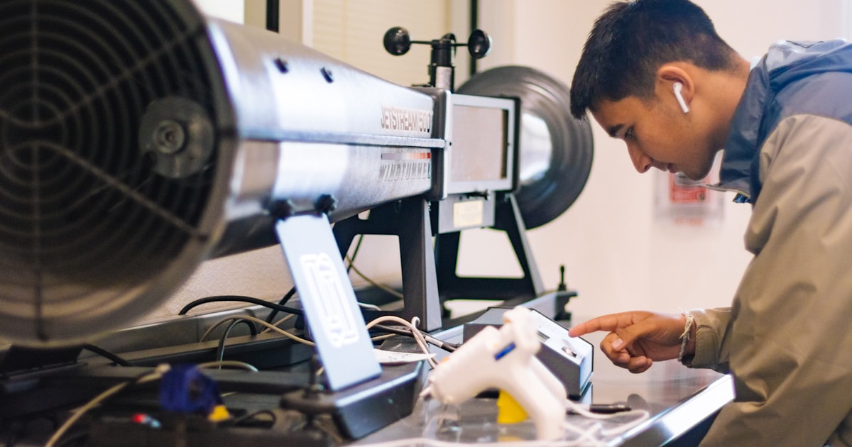 Technician using smartphone to check equipment diagnostics during HVAC service